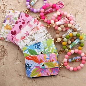 Detail of floral PU leather card holder wallet with silicone bead wristlet and tassel