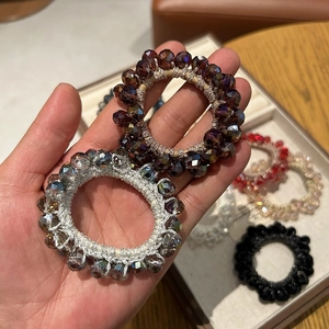Close-up of faceted crystal bead hair ties and elastic ponytail holders in warm tones