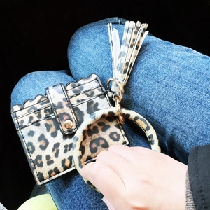 Nahaufnahme der Leopardenmuster-Brieftasche mit Armband und Quaste auf Denim