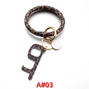 Detail view of leopard print leather wristlet keychain with acrylic door opener tool