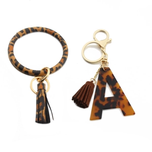 Detail of leopard print PU leather ring keychain with acrylic letter A and tassel pendant