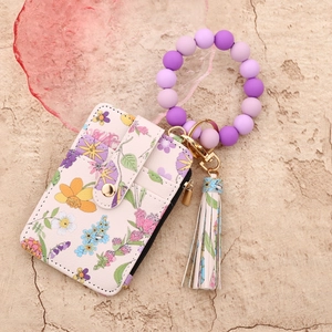Macro shot of floral card holder wallet with purple silicone bead keychain and gold clasp