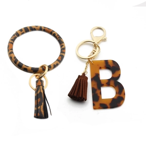 Detail of leopard print PU leather wristlet and letter B keychain with golden hardware