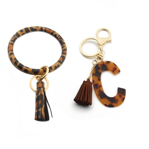 Detail of leopard print leather wristlet keychain and tortoise shell acrylic letter C charm