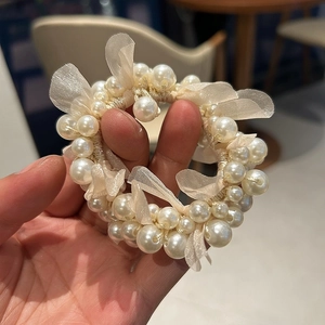 Detailed close-up of pearl scrunchie with camellia mesh petals and elastic hair band