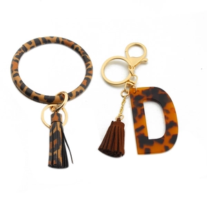 Detailed view of leopard print PU leather wristlet keychain with acrylic letter D charm