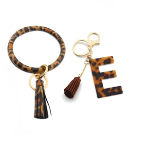 Close-up of leopard print PU leather wrist ring with tortoiseshell acrylic letter E keychain