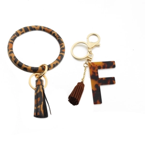 Detail of leopard print PU leather wristlet keychain with acrylic letter F and fringe