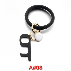 Detail of PU leather bracelet keychain with gold metal ring and black no-touch door opener