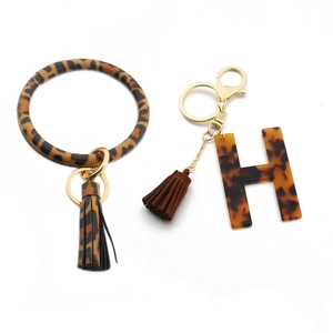 Detail of leopard print PU leather ring and tortoiseshell acrylic letter H keychain charms