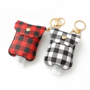 Detail view of portable PU leather sanitizer holders with plaid patterns and gold clips