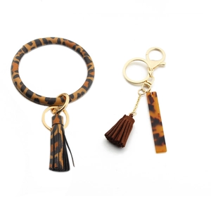Macro detail of leopard print PU leather wristlet key ring with tassels and acetate charm