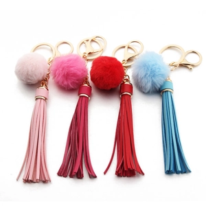 Detail of colorful PU leather tassel keychains with plush balls and golden metal clasps