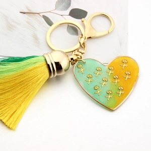 Detail of heart-shaped keychain with gold roses, gradient tassel and lobster clasp