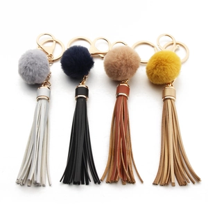 Detail of four colorful PU leather tassel keychains with pompom and golden spring rings