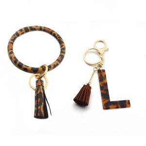 Detail of leopard print PU leather keychain with gold metal clasp and letter L charm