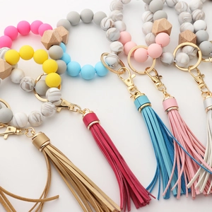 Detail view of silicone bead keychain with wooden accents and elegant leather tassels