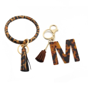 Detail of leopard print PU leather wristlet and acrylic letter M keychain set