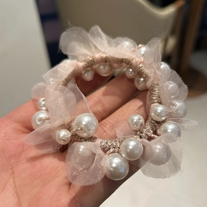 Close-up of pearl mesh hair tie with pink camellia style and elastic texture