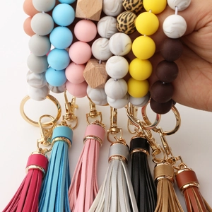 Detail of colorful silicone and wood bead wristlet keychains with leather tassels and lobster clasp