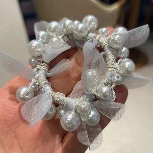 Detail of grey mesh scrunchie with scattered pearls and camellia flower texture