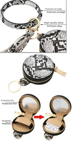 Détail macro du bracelet portefeuille serpent avec miroir intégré et étui pour écouteurs
