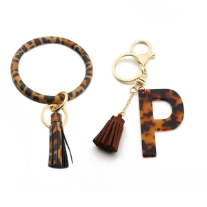 Close-up of leopard print PU leather wristlet and acrylic letter P keychain tassel charm