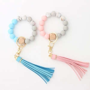 Close-up of food grade silicone beads with wooden hex bead and tassel keychain on white