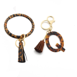 Detail view of leopard print PU leather wristlet and tortoiseshell resin letter Q charm