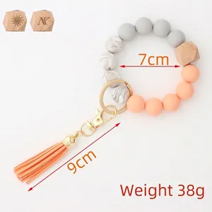 Silicone and wood beaded keychain bracelet with orange leather tassel and gold ring
