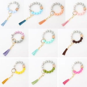 Macro detail of silicone beaded wristlet keychain with wooden bead and leather tassels