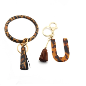 Detail of leopard print leather wristlet and tortoiseshell resin letter U keychain pendant