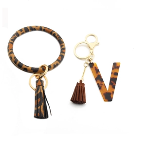 Detail of leopard print PU leather keychain wristlet with acrylic letter V and tassel