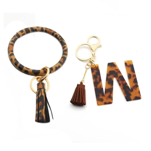 Detail of leopard print PU leather bracelet key ring with acrylic letter W pendant and tassel