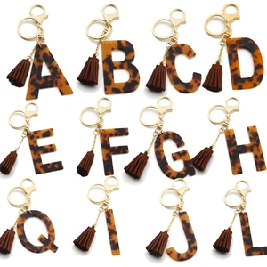 Leopard print acrylic alphabet keychains with brown suede tassels and gold rings