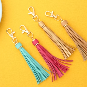 Detailed view of four colorful PU leather tassel keychains with golden metal lobster clasps