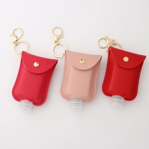 Three colorful PU leather keychain holders for hand sanitizer bottles on white background