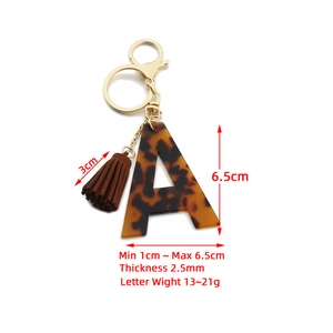 Leopard print acrylic letter A keychain with brown tassel and gold hardware on white background