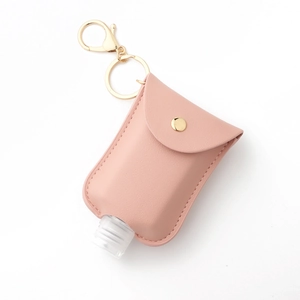 Pink PU leather hand sanitizer keychain holder with gold metal ring on white background