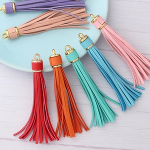 Detail showing multi-color PU leather tassels with gold metal caps and rings for keychains