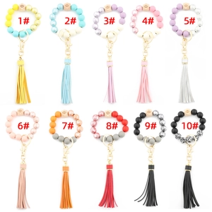 Detailed grid of ten assorted silicone and printed wooden bead tassel keychain bracelets