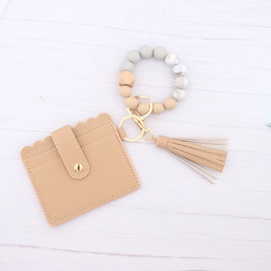 Detail of beaded silicone bracelet with scalloped PU leather card holder and tassel