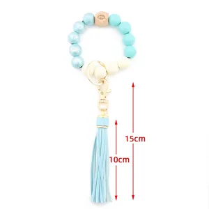Beaded keychain bracelet featuring printed beech wood beads and a light blue leather tassel