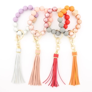 Close-up of printed wooden beads and faux leather tassels on colorful keychain bracelets