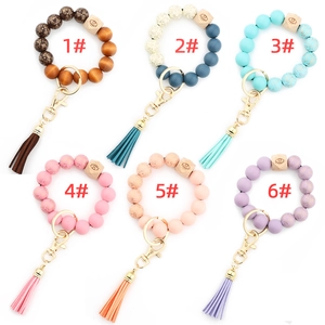 Patterned wood bead bracelet keychains with PU tassels and evil eye charms in six colors