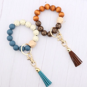 Beaded keychain bracelet with printed wooden beads, silicone beads, and leather tassels