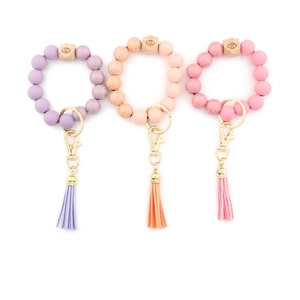 Close-up of silicone beaded keychain bracelets with wooden charms and PU tassels