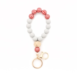 Detail of Christmas beaded keychain with red white stripes, grey beads and wood hexagon bead