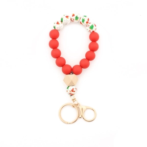 Détail d'un porte-clés de Noël en perles de silicone avec motifs de Père Noël et bois