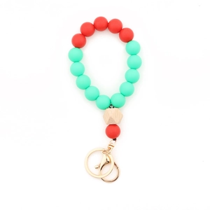 Détail du porte-clés en perles de silicone rouge et vert avec perle bois et fermoir doré